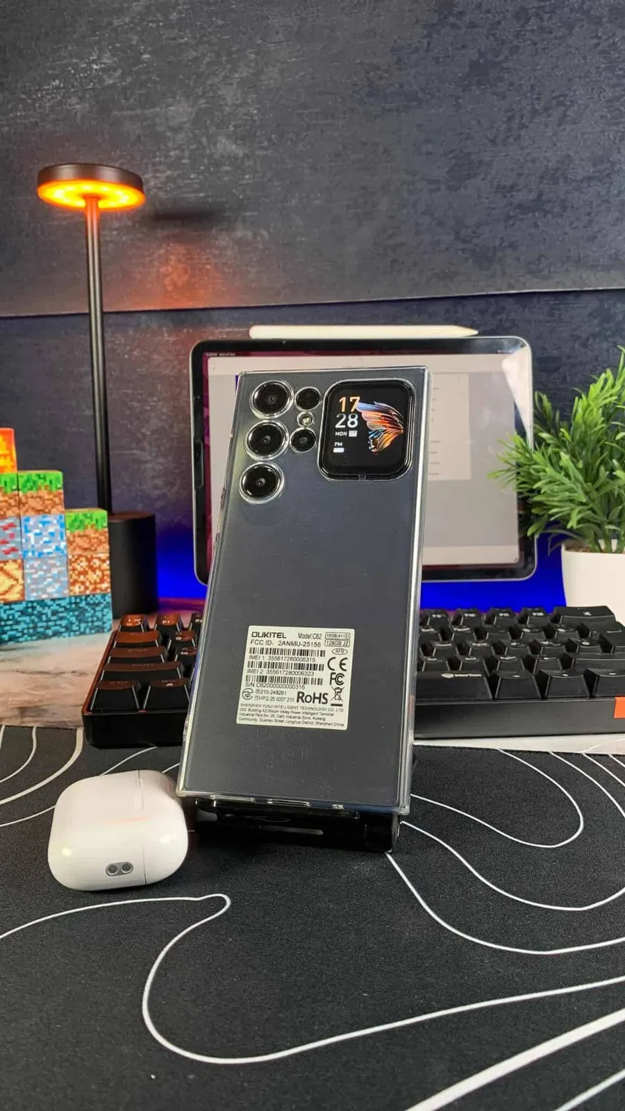 هاتف OUKITEL C62 باللون الأسود من الخلف، والشاشة الخلفية تعرض الساعة